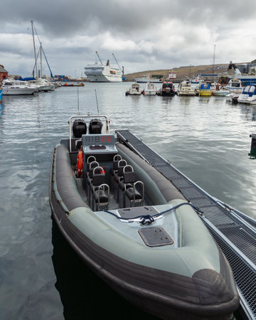 Thorshavn, Faroe Islands, Denmark - 03 May 2018: Fast boat moored in the port. A large passenger ferry of the Smyril-Line in the background.のeditorial素材