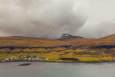 View of the small town of Ljosa on the island of Eysturoy. Volcanic archipelago in the Atlantic Ocean. Beautiful sunset. Faroe Islands. Denmark.の写真素材
