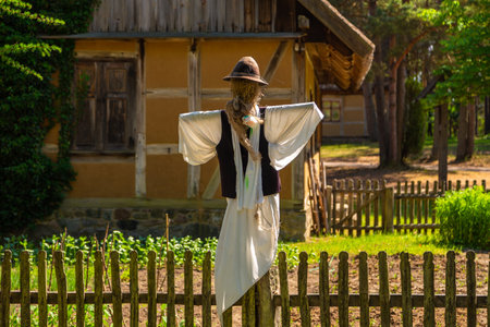 Wdzydze Kiszewskie, Poland - 31 May 2018: Scarecrow against thatched cottage in open-air museum, Kashubian Ethnographic Park.のeditorial素材