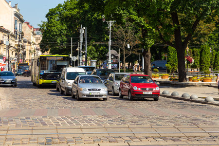 Lviv, Ukraine 09 June 2018: Traditional buildings in a cobblestone street in historical Old town of Lviv. Cars on the street.のeditorial素材