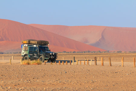 Soussusvlei, Namibia - 29 September 2018: Typical 4x4 rental car in Namibia equipped with camping gear and a roof tent. The famous 45 dune in the background. Namibian wilderness.のeditorial素材