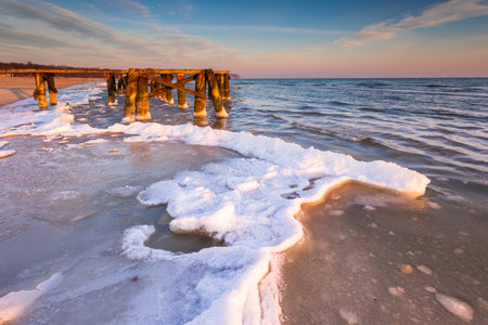 Early morning at frozen elements of small pier at beach in Sopot. Winter landscape in Sopot, Poland.の写真素材
