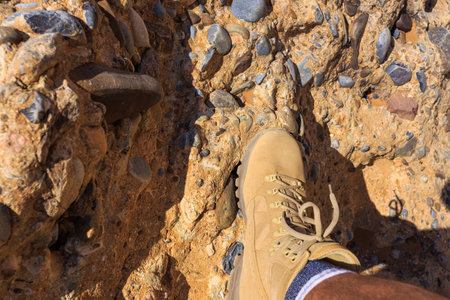 Sesriem, Sossusvlei, Namibia - 30 September 2018: A tourist in the shoes of the renowned Meindl brand. Mountain, climbing and trekking shoes.のeditorial素材