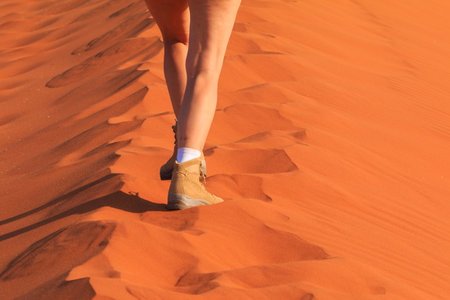 Sesriem, Sossusvlei, Namibia - 30 September 2018: A tourist in the shoes of the renowned Meindl brand. Mountain, climbing and trekking shoes. Famous dune 45.のeditorial素材