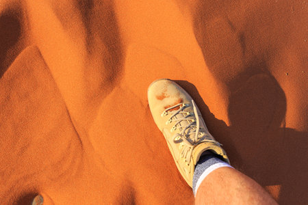 Sesriem, Sossusvlei, Namibia - 30 September 2018: A tourist in the shoes of the renowned Meindl brand. Mountain, climbing and trekking shoes. Famous dune 45.のeditorial素材