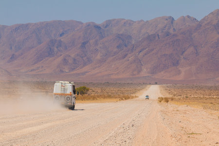 Sesriem, Naukluft , Namibia - 01 October 2018: Typical 4x4 rental car in Namibia equipped with camping gear and a roof tent driving on a dirt road through the Namibian wilderness.のeditorial素材