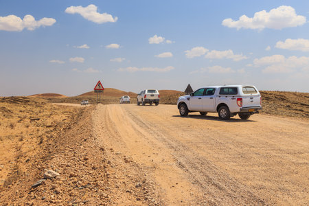 Khomas Region Capricorn, Namibia - 02 October 2018: Typical 4x4 rental car in Namibia equipped with camping gear and a roof tent driving on a dirt road through the Namibian wilderness.のeditorial素材