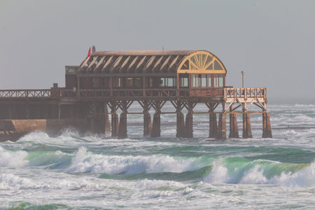 Old historic German jetty in Swakopmund Namibia, South Africa. High waves in the Atlantic Ocean.の写真素材