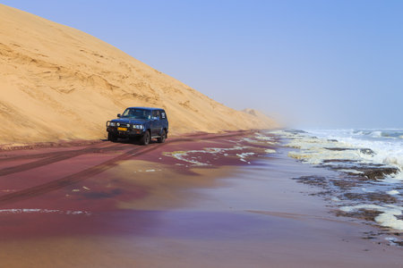 Sandwich Harbor - 03 October 2018: 4x4 trip on a beach. Rough waves of the Atlantic Ocean off the coast of Namibia.The northern part of the Namib Desert.のeditorial素材
