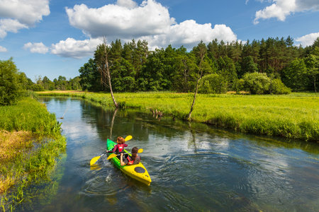 Kashubia, Pomerania, Poland- July 14, 2019: Radunia river flowing through the lakes. People kayaking. Forest around, summer season.のeditorial素材