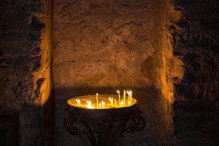 Interior of the Dadivank or Khutavank, Devotional wax orange candles in a row. Armenian Apostolic monastery in the Kalbajar. Dadivank, Azerbaijan.の写真素材