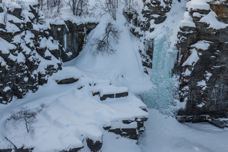 Snowy landscape in winter day time. Mountain river canyon. Abisko National Park, Lapland, Sweden.