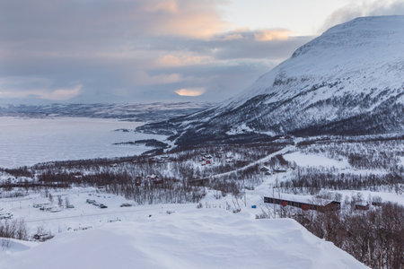 A frosty winter day at the Tornetrask Lake. The lake is covered in ice. Winter season. Bjorkliden, Lapland, Sweden.の写真素材