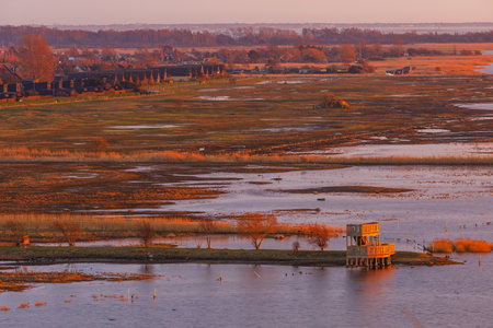 View of coastal wetlands and a wooden observation deck at golden hour in Lernacken, Sweden.の写真素材