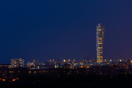 The iconic Turning Torso skyscraper and city lights in Malmo, Sweden, seen after dusk.