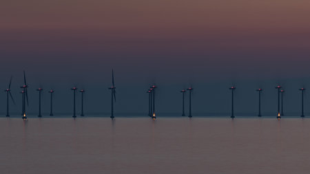 Offshore wind farm in Oresund Strait near Malmo, Sweden, captured at sunset in warm tones.の写真素材