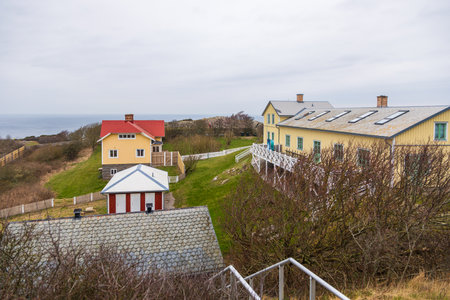 Charming yellow wooden house with red roof and sea view in Sweden. Coastal scenery.の写真素材
