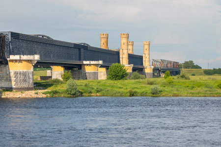 Steel railway bridge with brick towers spans the Vistula River in Tczew, northern Poland.の写真素材