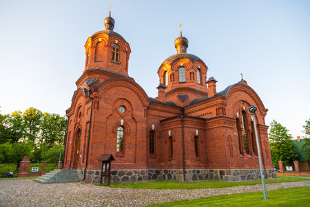 Bialowieza, Poland - June 3, 2021: Orthodox church with red brick towers, domes, and decorative windows at sunset.の写真素材