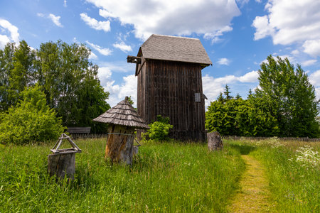 Traditional wooden windmill with historic beehives on a grassy meadow in Bialowieza, Poland.の写真素材