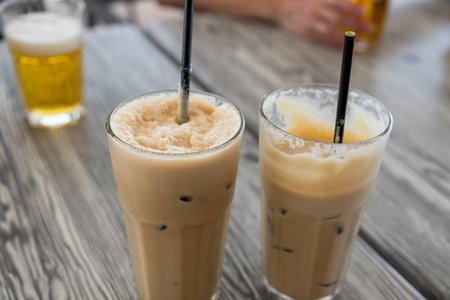Two glasses of iced coffee with straws served on a wooden table in Marsaxlokk, Malta.の写真素材