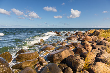 Rocky Baltic Sea shoreline with waves hitting large coastal boulders in Lahemaa National Park, Estonia.の写真素材