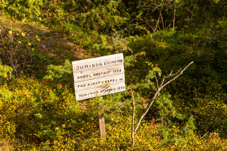 Lahemaa, Estonia â September 01, 2021: Wooden sign indicating the site of the first chapel of Juminda village from 1578, located in a forested area of Lahemaa National Park.のeditorial素材