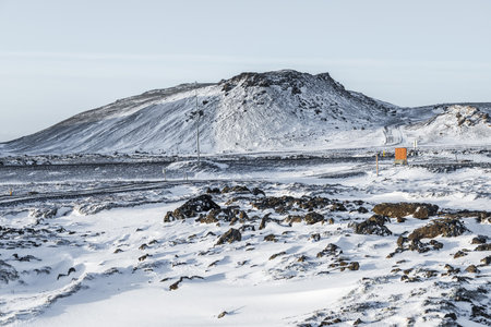 Wide view of a snow covered volcanic landscape with lava rocks and mountains on the Reykjanes Peninsula near Grindavik, Iceland, during winter.の写真素材