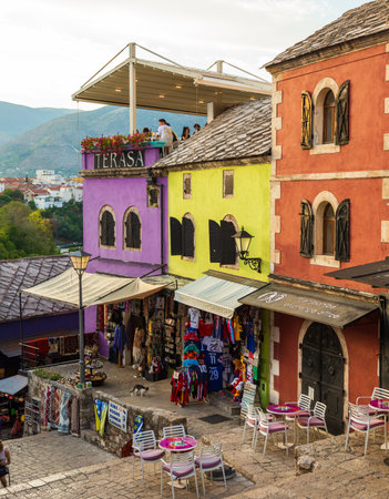 Mostar, Bosnia and Herzegovina, August 16, 2022. People sitting and shopping among colorful historic buildings in the old town.のeditorial素材