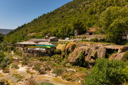 Stolac, Bosnia and Herzegovina â August 17, 2022: Riverside area with traditional stone buildings, rocky terrain and green hills near the town of Stolac.のeditorial素材