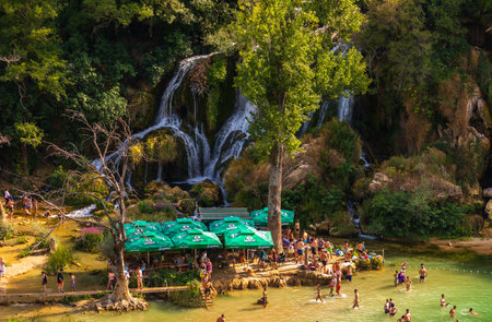 Kravica falls, Bosnia and Herzegovina - August 18, 2022: People swimming and relaxing at Kravica waterfall, a popular summer destination in Ljubuski.のeditorial素材