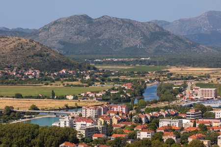 Trebinje, Bosnia and Hercegovina - August 21, 2022: Trebinje cityscape along the Trebisnjica River, rooftops and trees in a sunny mountain valley.のeditorial素材