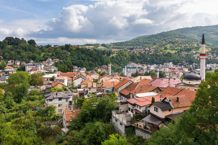 Travnik, Bosnia and Hercegovina - August 24, 2022: Travnik city panorama nestled in a valley, showing houses, green hillsides, and a mosque minaret.のeditorial素材