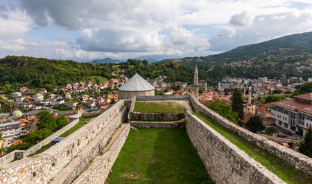 Travnik, Bosnia and Hercegovina - August 24, 2022: Ancient fortress walls above historic Travnik with minarets, green hills and distant mountains.のeditorial素材