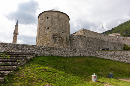 Travnik, Bosnia and Hercegovina - August 24, 2022: Travnik Fortress stone walls and round tower with minaret under cloudy Bosnian sky.のeditorial素材