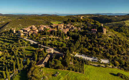 Monticchiello, Italy - November 06, 2022:  Monticchiello historic buildings and cypress trees...