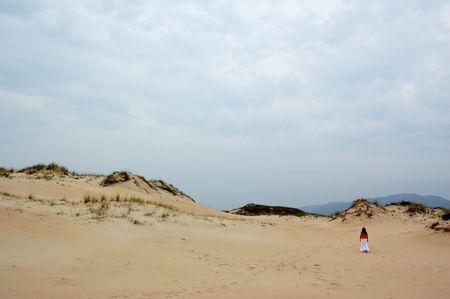 young girl walking on corrubedo dunesの写真素材