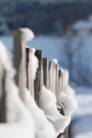 Closeup of Wooden Fence covered in Snow with a out of focus Background. Bokeh Background and Snow in the foreground,の写真素材
