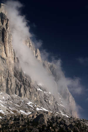 Langkofel with some clouds hanging on the side during a sunny day. The Langkofel is located in the DOlomites just above Val Gardena in Alto Adigeの写真素材