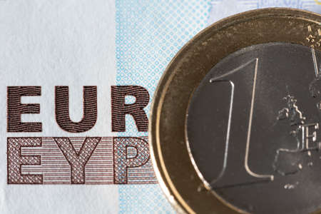 One Euro Coin and 20 Euro Banknote in background with EUR writing. Finance and personal welath conceptの写真素材