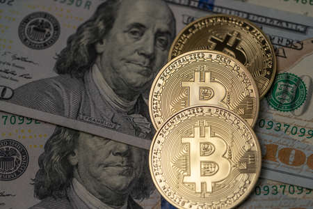 Gold Bitcoin coins on top of 100 Dollar Banknotes. Crypto currency and Fiat currency. Digital Money...