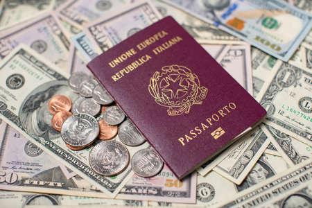 Italian Passport on top of US Dollar Banknotes and Coins. Travel to the United States of America. Italy Identification Passport. Travel Expensesの写真素材