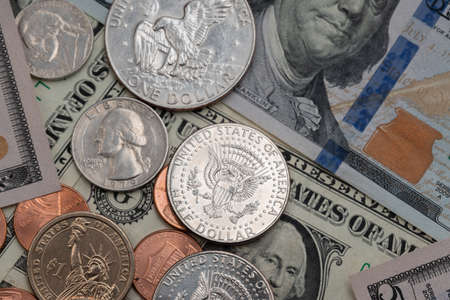 United States Dollar coins on top of Banknotes. Half Dollar coin on a one hundred Dollar Bill. Federal Reserve Banknoteの写真素材