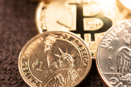 One US Dollar coin with Gold Bitcoin out of Focus. Digital Crypto Currency trading to USD....
