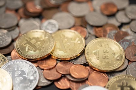 A pile of coins, US dollar coins next to Crypto coins. Gold and silver Bitcoins on top of copper...