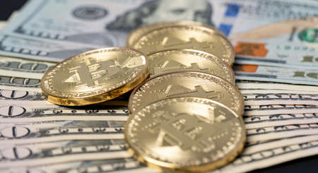Piled up bitcoin on fifty and one hundred dollar banknotes. Digital currency trading to US dollar...