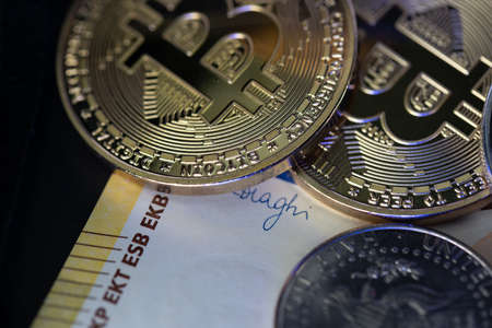 Gold Bitcoin on 200 Euro banknote and Half Dollar coinの写真素材
