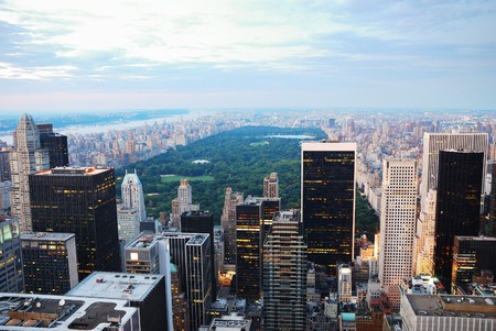 New York City at dusk with central park surrounded by skyscrapers with lightsの写真素材