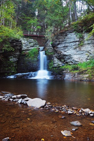 Waterfall in mountain with lake and woodsの写真素材