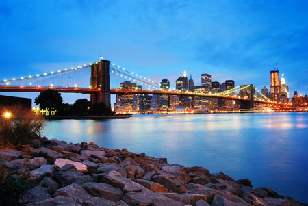 Brooklyn Bridge and Manhattan skyline in New York City over Hudson River at night.の写真素材